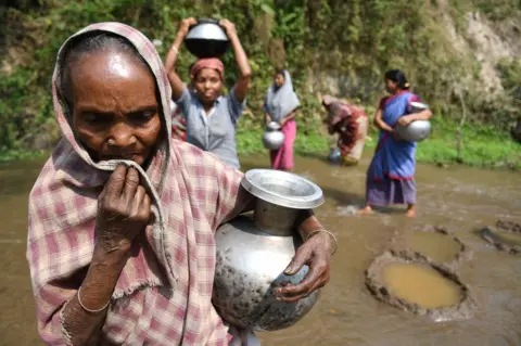Women walking miles for water